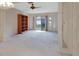 Bright living room with large sliding doors, neutral carpet, and an empty bookcase at 244 Oakleigh Dr # 200, Deland, FL 32724