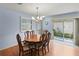 Dining room with wood table and chairs and access to the patio through sliding glass doors at 2610 Hialeah Ave, The Villages, FL 32162