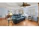 Open-concept living room with hardwood floors, blue sofa, and plenty of natural light at 2610 Hialeah Ave, The Villages, FL 32162