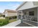 Enclosed patio with dining table and fan, with a view of the yard and neighboring houses at 2610 Hialeah Ave, The Villages, FL 32162