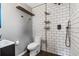 Modern renovated bathroom with a walk-in shower featuring decorative tile, modern fixtures, and natural stone floors at 303 Warwick Ave, Ormond Beach, FL 32174