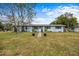 Adorable one-story home with a neatly kept lawn and charming flower pots leading to the entrance at 303 Warwick Ave, Ormond Beach, FL 32174