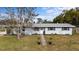Lovely one-story home with a manicured lawn and blooming plants, offering a welcoming entrance at 303 Warwick Ave, Ormond Beach, FL 32174