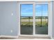 View of blue skies and ocean through the sliding glass doors leading to the balcony at 3180 Ocean Shore Blvd # 309, Ormond Beach, FL 32176