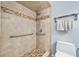 Bathroom featuring a walk-in shower with grab bars and tiled surround at 3180 Ocean Shore Blvd # 309, Ormond Beach, FL 32176