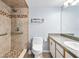 Bathroom featuring a walk-in shower with stylish tile, safety bars, and updated vanity at 3180 Ocean Shore Blvd # 309, Ormond Beach, FL 32176