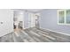 Comfortable bedroom showcasing light gray plank flooring, leading to a bathroom and kitchen at 3180 Ocean Shore Blvd # 309, Ormond Beach, FL 32176