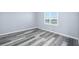 Bedroom featuring new gray wood-look flooring, neutral paint, and a window with blinds at 3180 Ocean Shore Blvd # 309, Ormond Beach, FL 32176