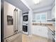 Well-equipped kitchen featuring stainless steel appliances, a laundry area, and bright white cabinetry at 3180 Ocean Shore Blvd # 309, Ormond Beach, FL 32176
