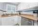Well-lit kitchen with stainless steel appliances, white cabinets, laminate countertops, and charming blue tile backsplash at 3180 Ocean Shore Blvd # 309, Ormond Beach, FL 32176