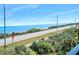 Here is an ocean view showing the beach, a road, and the clear blue ocean at 3180 Ocean Shore Blvd # 309, Ormond Beach, FL 32176