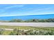 This is an ocean view showing the beach, a road, and the clear blue ocean at 3180 Ocean Shore Blvd # 309, Ormond Beach, FL 32176