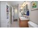 Bright bathroom featuring a vanity with wooden cabinets, a large mirror, and a storage cabinet at 35909 Joewood Ave, Leesburg, FL 34788