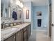 Well-lit bathroom featuring dual sinks, granite countertop, and decorative backsplash at 35909 Joewood Ave, Leesburg, FL 34788