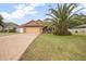 Charming home with a lush lawn, brick driveway, and eye-catching tree at 35909 Joewood Ave, Leesburg, FL 34788