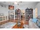 Spacious living room showcasing hardwood floors, bookcases, and views to kitchen at 35909 Joewood Ave, Leesburg, FL 34788