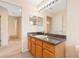 Bathroom vanity with wood cabinets, light fixtures, and a large mirror, creating a bright and functional space at 3633 Sickle St, Orlando, FL 32812