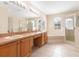 Bright bathroom featuring double sinks, vanity lighting, a soaking tub, and a glass-enclosed shower for a luxurious experience at 3633 Sickle St, Orlando, FL 32812
