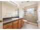 Well-lit bathroom featuring a granite countertop, glass-enclosed shower, and modern fixtures for a comfortable and stylish experience at 3633 Sickle St, Orlando, FL 32812