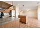 Open kitchen with stainless steel refrigerator, wooden cabinets, and tiled flooring leading to the living area at 3633 Sickle St, Orlando, FL 32812