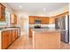 Spacious kitchen featuring tile floors, stainless steel appliances, wood cabinets and island at 3633 Sickle St, Orlando, FL 32812