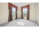Bright living room with large windows, soft carpet, and elegant chandelier at 3633 Sickle St, Orlando, FL 32812