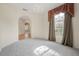 Sunlit living room featuring large windows, neutral carpet, and arched entryway at 3633 Sickle St, Orlando, FL 32812