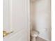 Toilet room with a white toilet, toilet paper holder, and closed door at 3633 Sickle St, Orlando, FL 32812