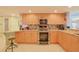 Modern kitchen with stainless steel appliances and wood cabinets at 4 Oceans West Blvd # 502D, Daytona Beach Shores, FL 32118