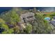 Aerial view of a sprawling luxury estate with a pool, dock, and mature trees on a lake at 510 Sandy Bluff Trl, Deland, FL 32724
