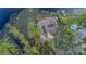 Aerial view showcases a lakefront luxury property with a private pool, dock, and lush landscaping at 510 Sandy Bluff Trl, Deland, FL 32724
