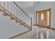 Bright entryway features tile flooring, a wooden staircase with white railings, and a decorative front door at 510 Sandy Bluff Trl, Deland, FL 32724