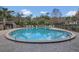 Community pool featuring a round design, surrounded by lounge chairs and mature trees at 510 Sandy Bluff Trl, Deland, FL 32724