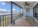 Screened porch featuring wood-look tile and views of the lake beyond the metal railing at 510 Sandy Bluff Trl, Deland, FL 32724