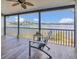Screened porch featuring wood-look tile and views of the lake beyond the metal railing at 510 Sandy Bluff Trl, Deland, FL 32724