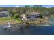 A sprawling rear exterior on lake, with a boat dock and lush greenery at 510 Sandy Bluff Trl, Deland, FL 32724