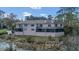 Expansive rear exterior view of home featuring an enclosed patio and tranquil lake views at 510 Sandy Bluff Trl, Deland, FL 32724