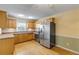 Traditional kitchen with wood cabinets, tile backsplash, and stainless-steel appliances at 564 Cambridge Cir, South Daytona, FL 32119