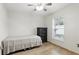 Neutral toned bedroom with tile floors, a window, a ceiling fan, and dark wood dresser at 583 Wilburton Dr, Deltona, FL 32738