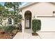 Close-up of a home's front entrance featuring a covered porch with an arched entry and well-maintained landscaping at 583 Wilburton Dr, Deltona, FL 32738