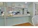 Bright kitchen pass-through with white cabinets, counter space, and appliances at 600 N Boundary Ave # 114B, Deland, FL 32720