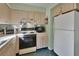 Functional kitchen featuring essential appliances, plentiful cabinet space, and easy access to the dining area at 600 N Boundary Ave # 114B, Deland, FL 32720