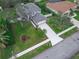 Aerial view of a home featuring a driveway, lush landscaping, and a gray shingle roof at 6150 Half Moon Dr, Port Orange, FL 32127