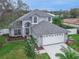 Aerial view of a beautiful gray two-story home with lush landscaping and a two car garage at 6150 Half Moon Dr, Port Orange, FL 32127