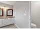 Bathroom featuring double sinks with granite countertops and a separate toilet room at 6150 Half Moon Dr, Port Orange, FL 32127