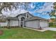 Charming gray two-story home showcasing a well-maintained lawn and inviting curb appeal at 6150 Half Moon Dr, Port Orange, FL 32127