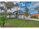 Beautiful two-story home with a well-manicured lawn, mature trees, and a charming exterior at 6150 Half Moon Dr, Port Orange, FL 32127