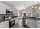 Modern kitchen featuring white cabinetry, granite countertops, and stainless steel appliances at 6150 Half Moon Dr, Port Orange, FL 32127