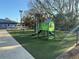 Community playground featuring modern play equipment and resilient, green synthetic turf at 6150 Half Moon Dr, Port Orange, FL 32127