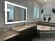 Bathroom featuring granite countertops, a lighted mirror, and a soaking tub with stylish tile surround at 6301 Swanson St, Windermere, FL 34786